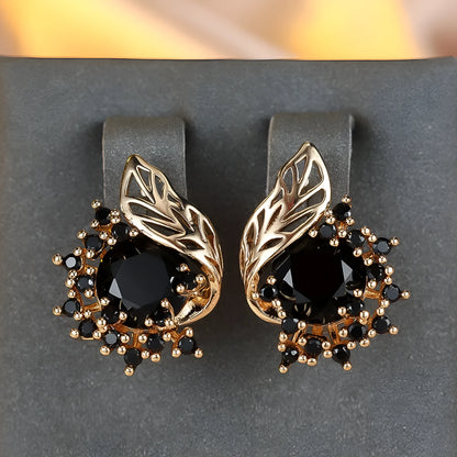 Rose gold plated women's stud earrings with a round flower shape, feather detail, and a central cubic zirconia stone.