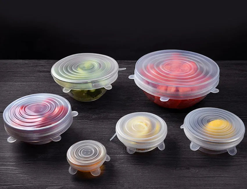 Set of six flexible silicone pot lids in assorted sizes on a kitchen counter.