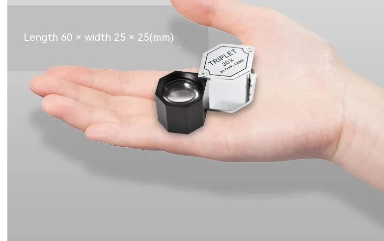 Handheld metal magnifying glass with optical glass lens for jewellery and coin inspection.