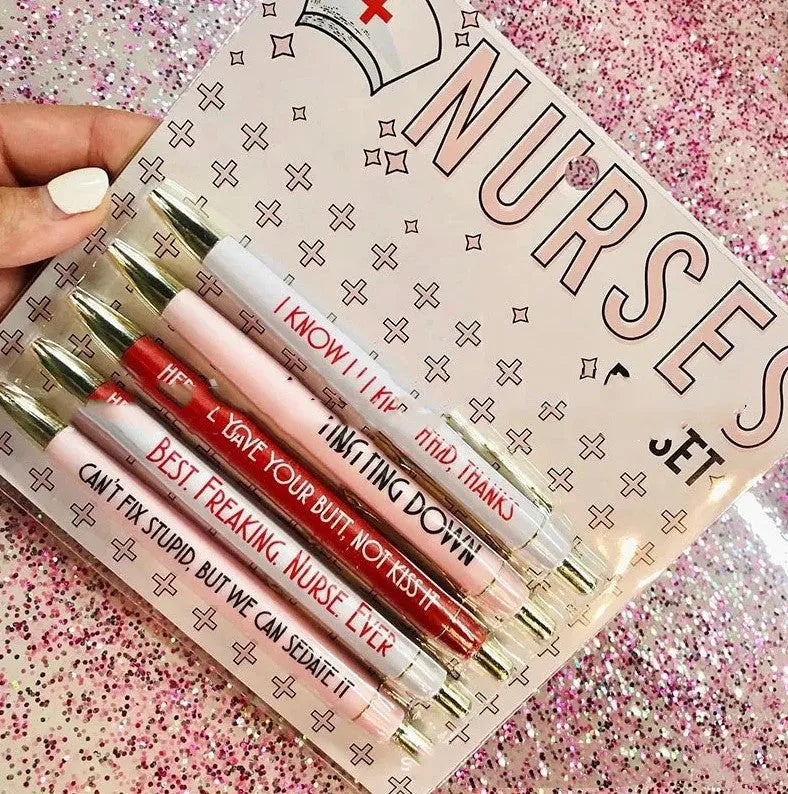 Set of five white plastic retractable ballpoint pens with blue and red nurse-themed text and graphics.