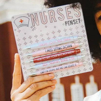Set of five white plastic retractable ballpoint pens with blue and red nurse-themed text and graphics.