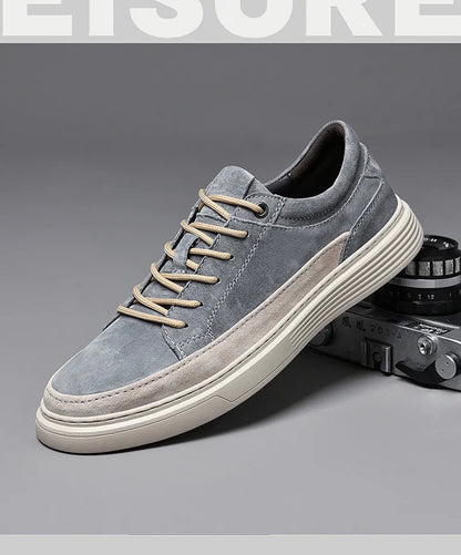 Men's grey low-top casual leather skate shoes with round toe and flat rubber sole on a plain background.