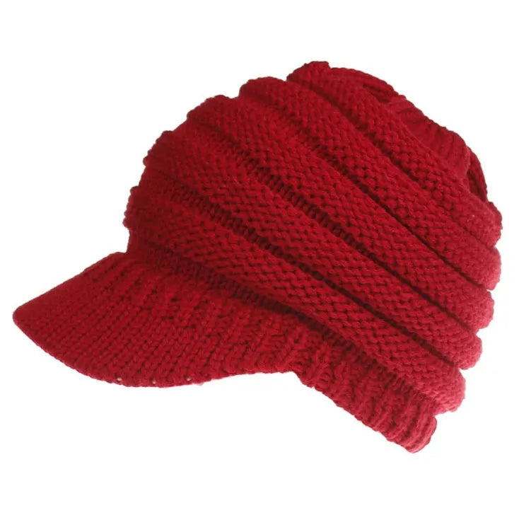 Women's acrylic knitted ponytail beanie in a solid colour, shown on a model with a ponytail.