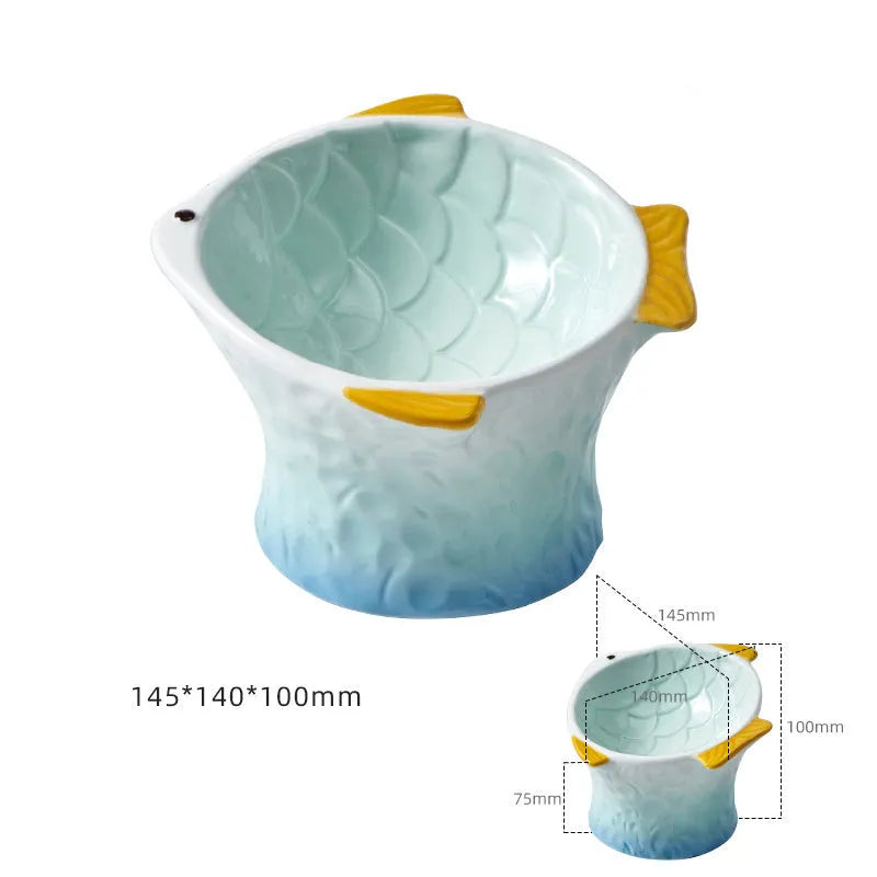 Set of four blue fish-shaped ceramic cat bowls with a tilted design on a wooden floor.