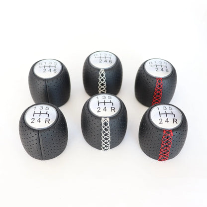 Sewn wrapped leather perforated style handball gear knob for Alpha vehicles in black, red, and white colour options.
