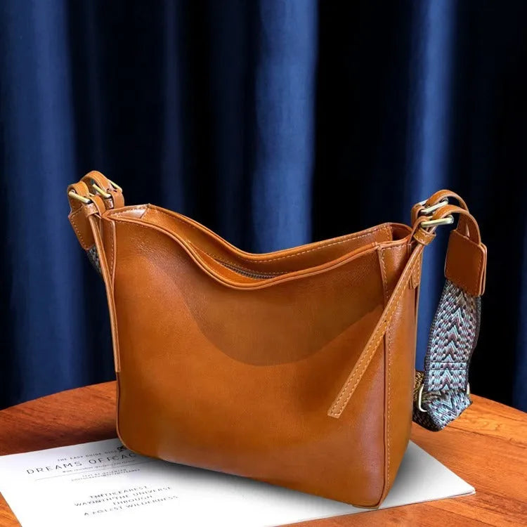 Women's black genuine leather shoulder messenger bag showing structured square shape and single strap.