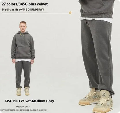 Man wearing solid colour cotton velvet sweatpants with an ankle banded design in a dark grey shade.