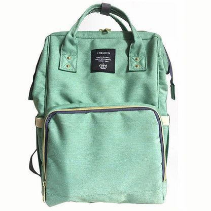 Stylish maternity diaper bag in various colors, featuring a paper bag design, separate bottle compartment, and discreet breastfeeding button.