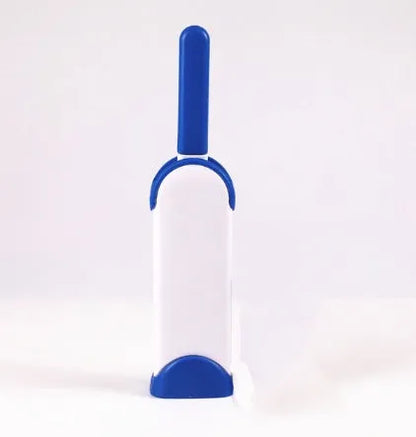 Blue reusable pet hair removal brush with double-sided head next to its self-cleaning base.