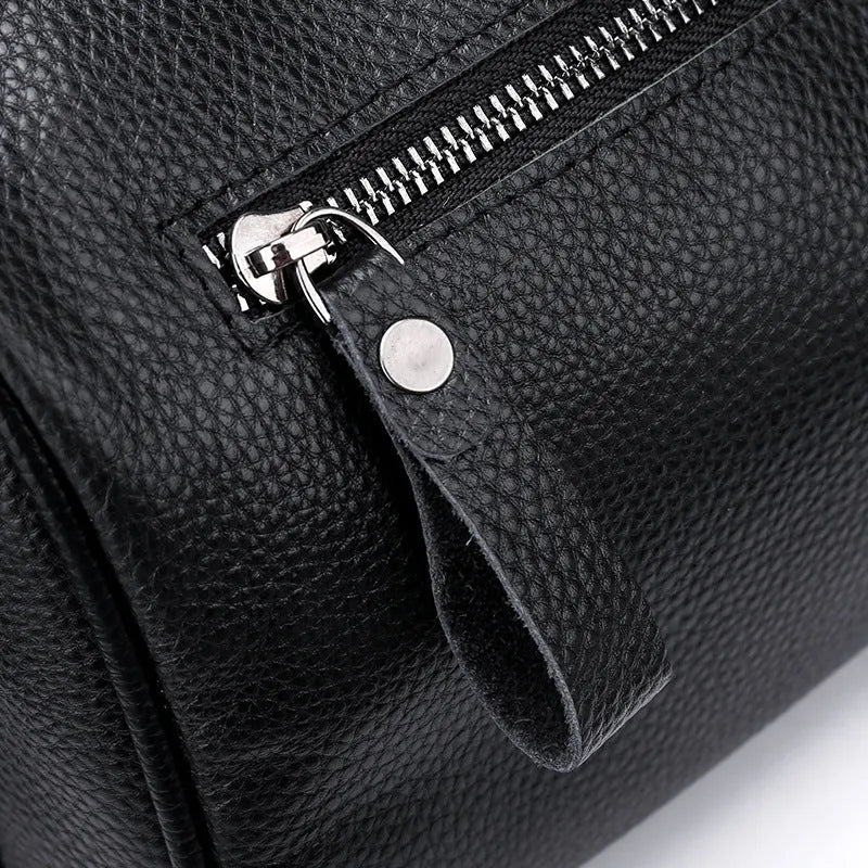 Black genuine leather one-shoulder crossbody bag with large main compartment and polyester lining.