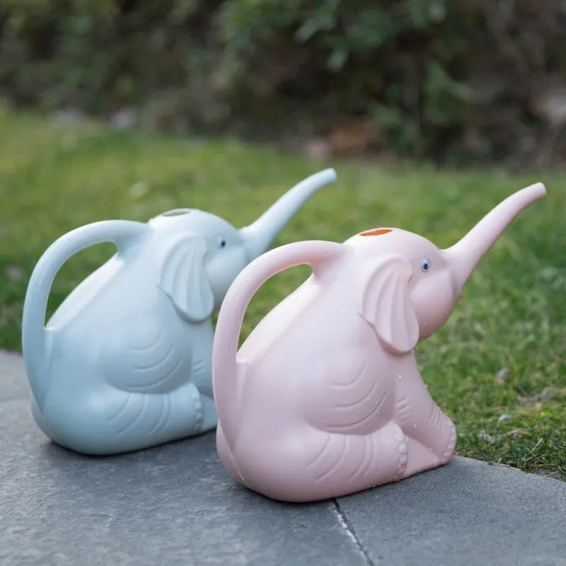 A pink children's elephant-shaped watering can with a long nozzle and baby bottle handle for gardening.