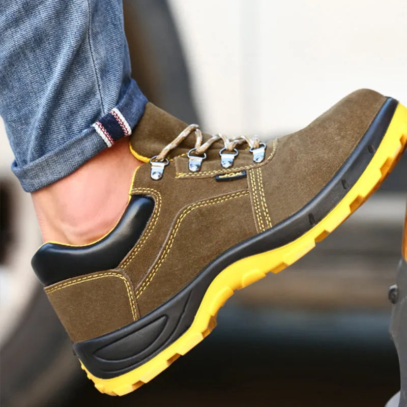 Bronze cow suede low-cut safety shoes with steel toe cap and patterned rubber sole on a workbench.