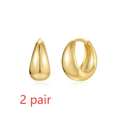 Geometric gold-tone stud earrings with a round centre on an earclip back, shown from the front.