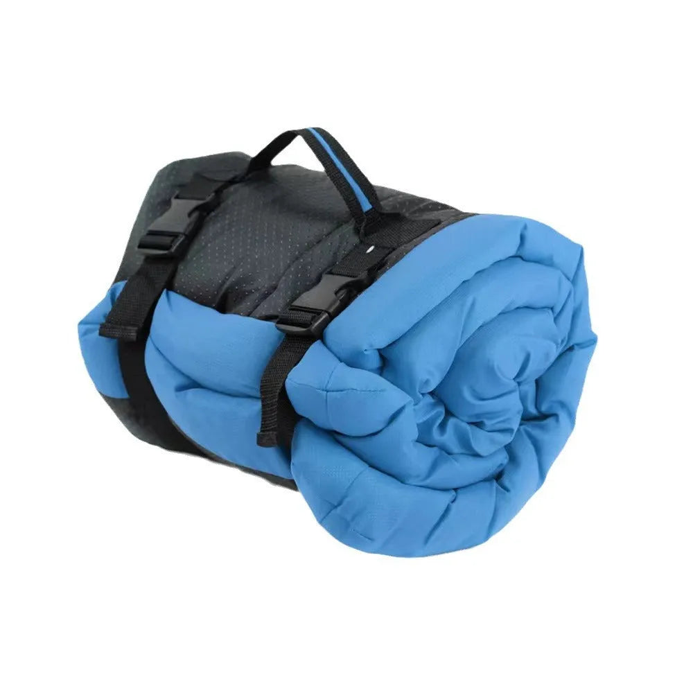 Blue foldable outdoor dog bed shown both fully unfolded and folded with buckles, on grass.