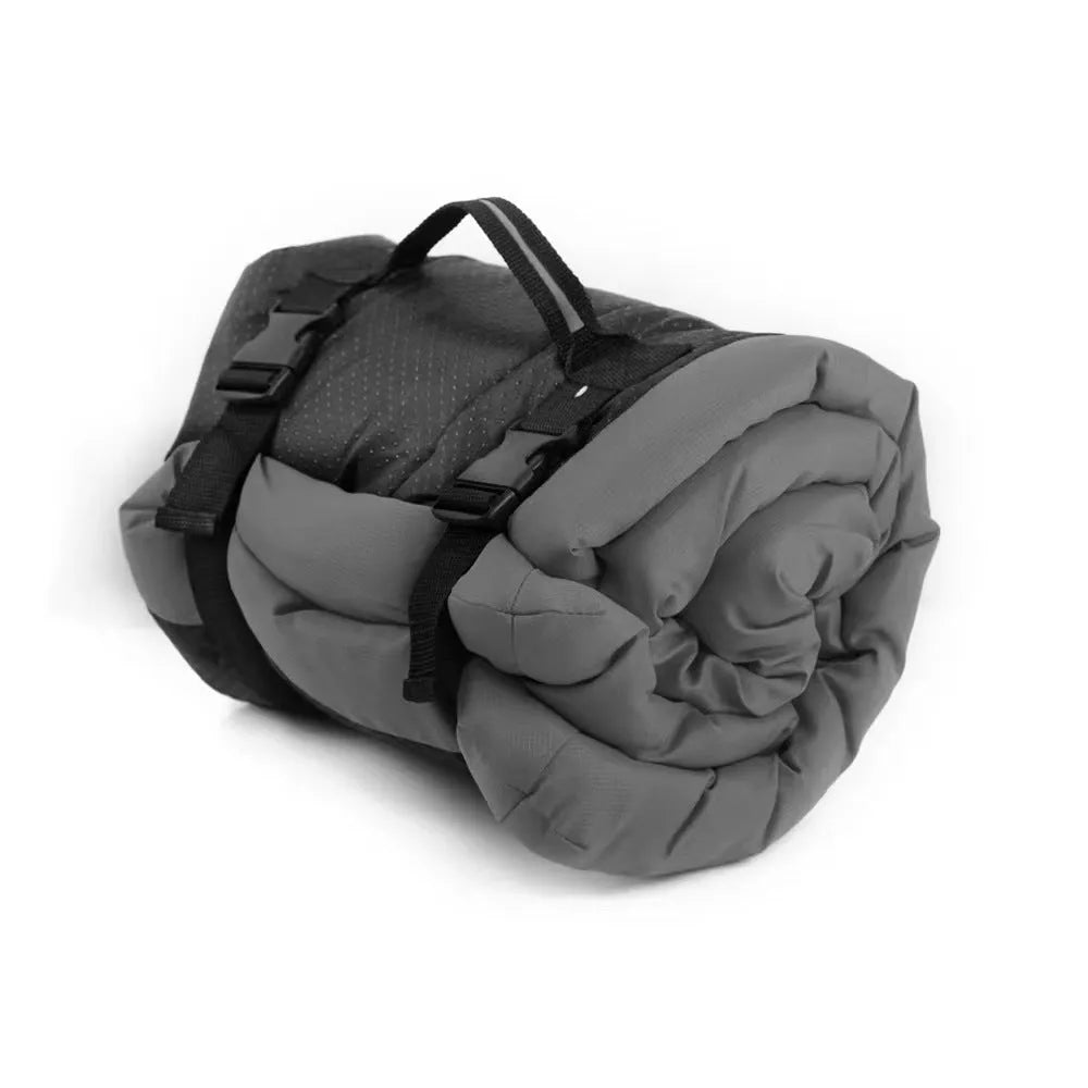 Blue foldable outdoor dog bed shown both fully unfolded and folded with buckles, on grass.