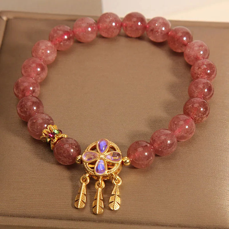 Women's strawberry quartz crystal bracelet with a four-leaf clover dream catcher pendant.