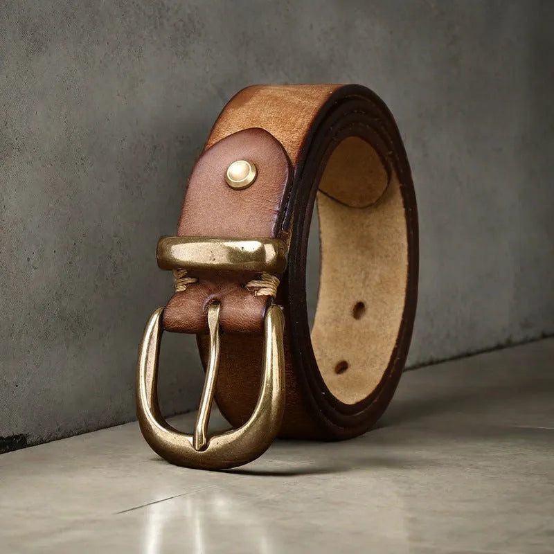 Men's black cattlehide leather jeans belt with a copper pin buckle shown on a flat surface.