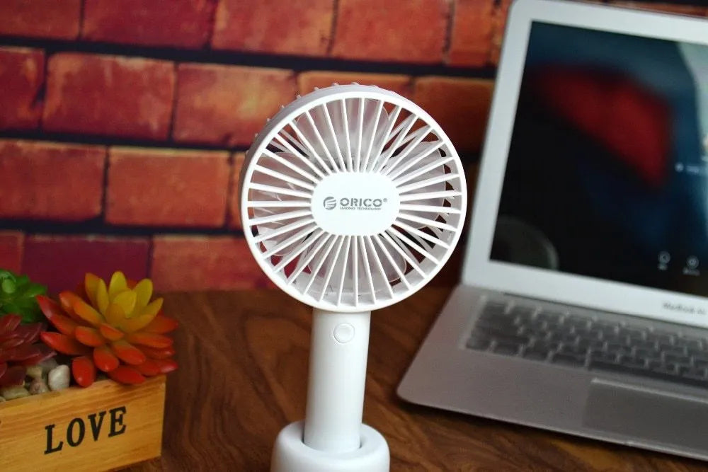 White ORICO FH1 portable USB rechargeable desk and handheld small fan with three speed buttons.