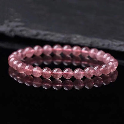 A women's bracelet made of polished strawberry quartz crystal beads in one of three size options.