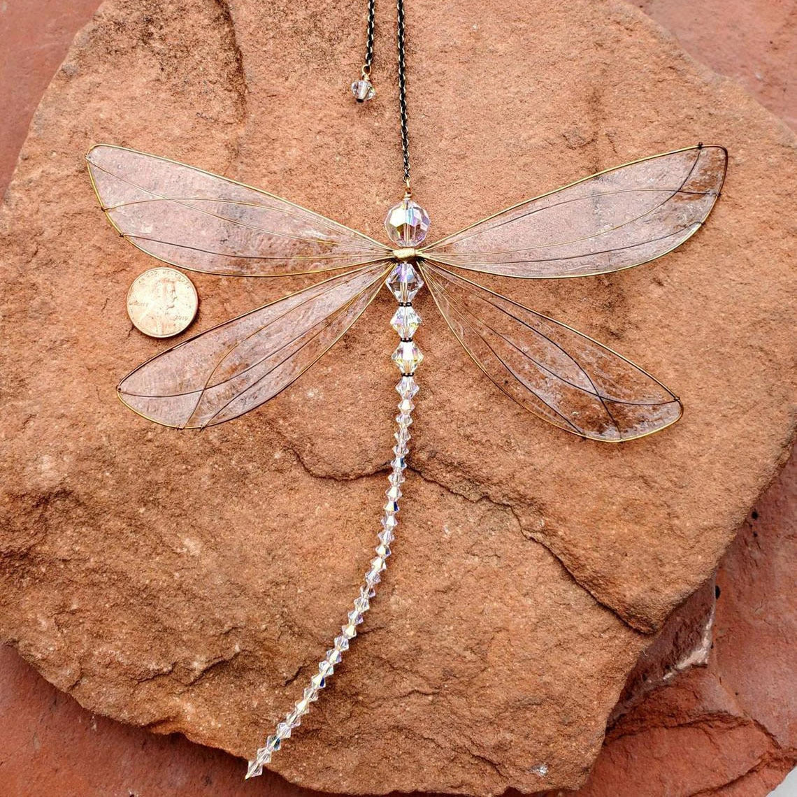 Elegant dragonfly-shaped crystal suncatcher with vibrant rainbow reflections