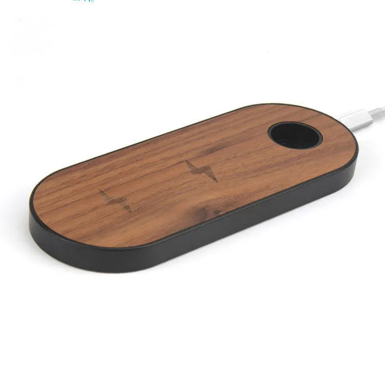 Ultra-thin bamboo and wood wireless charging stand for smartphones on a desk.
