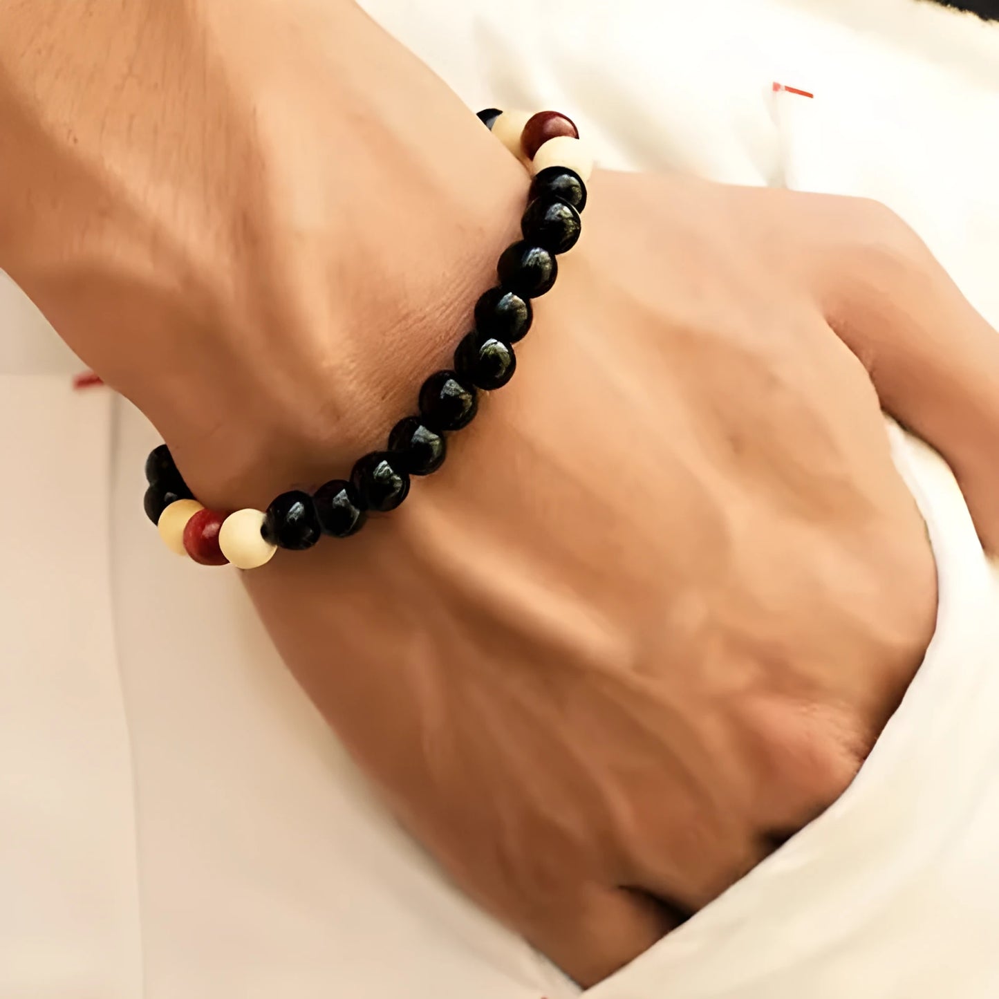 An ethnic-style natural stone bead bracelet with lava stones on a wrist.