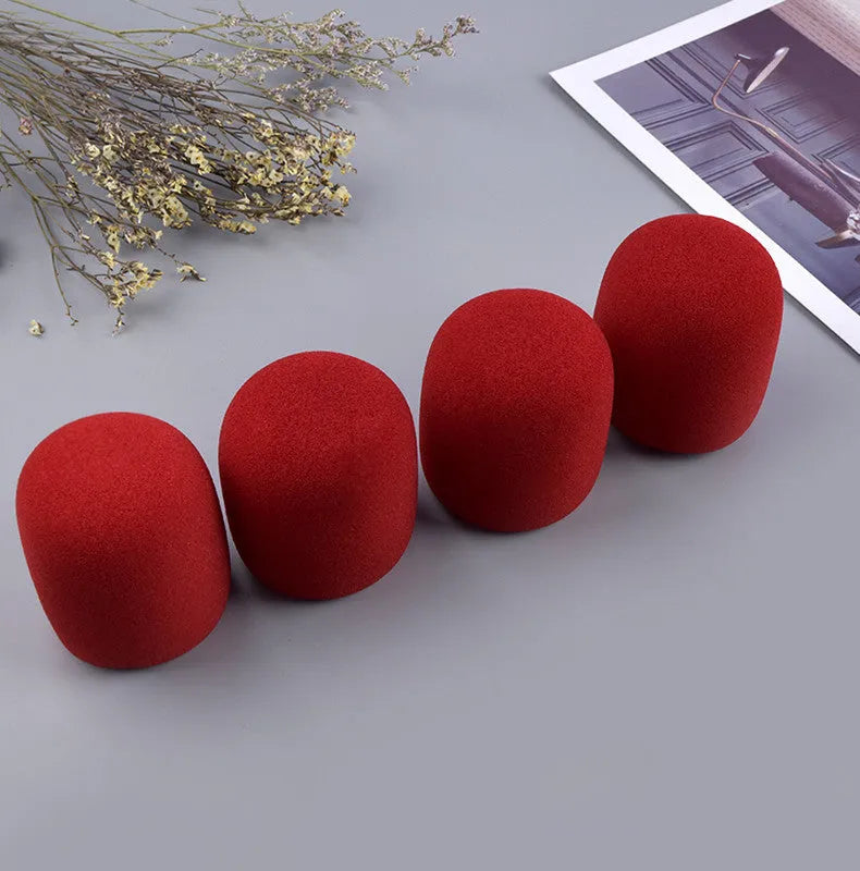 Four foam microphone wind shields in different colours for handheld stage microphones