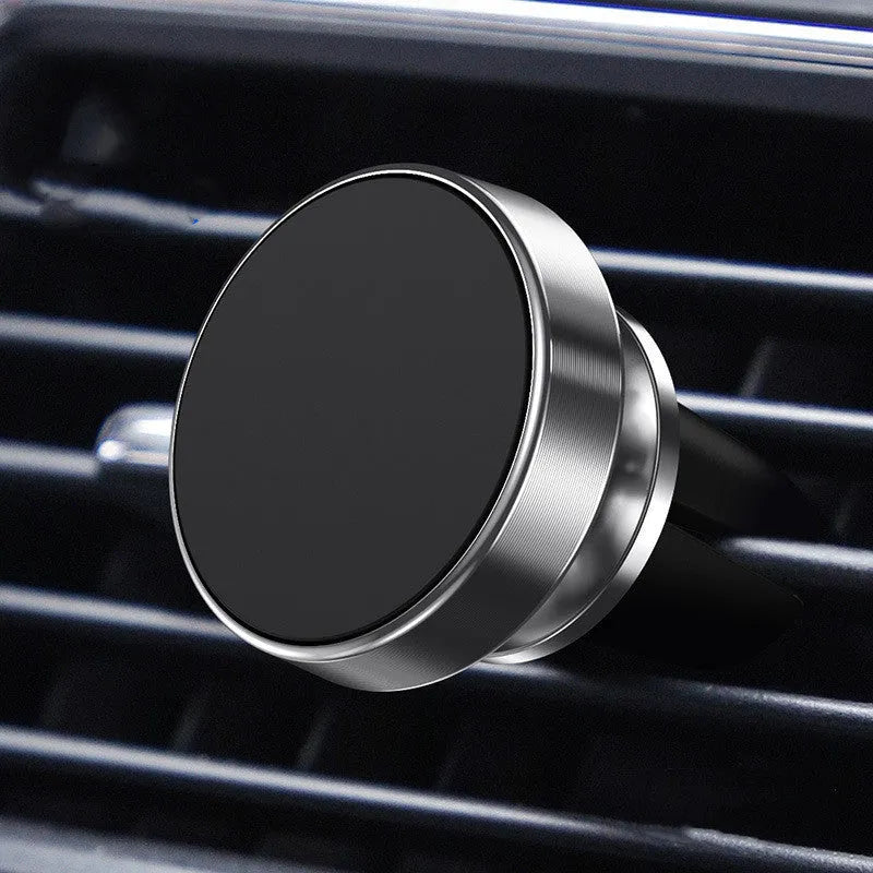 Silver aluminium alloy magnetic car phone holder with rotating ball head mounted on a car air vent.