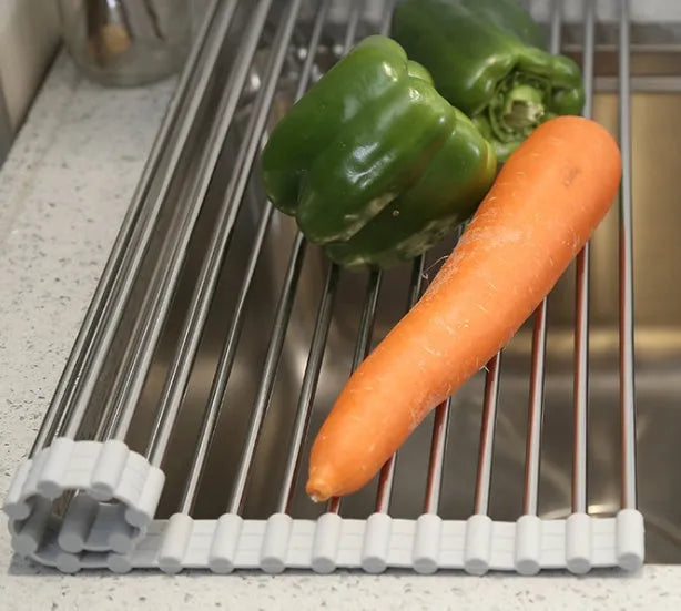 Folding stainless steel kitchen drain rack with coloured plastic tubes, shown open for use.