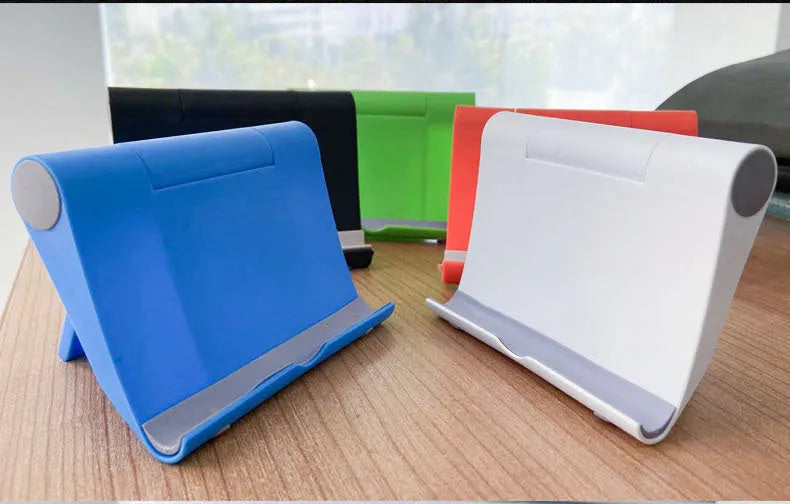 Black PE folding mobile phone stand holding a smartphone at an angle on a desktop.