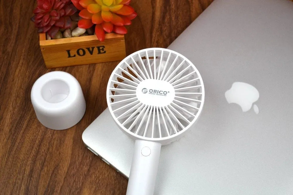 White ORICO FH1 portable USB rechargeable desk and handheld small fan with three speed buttons.