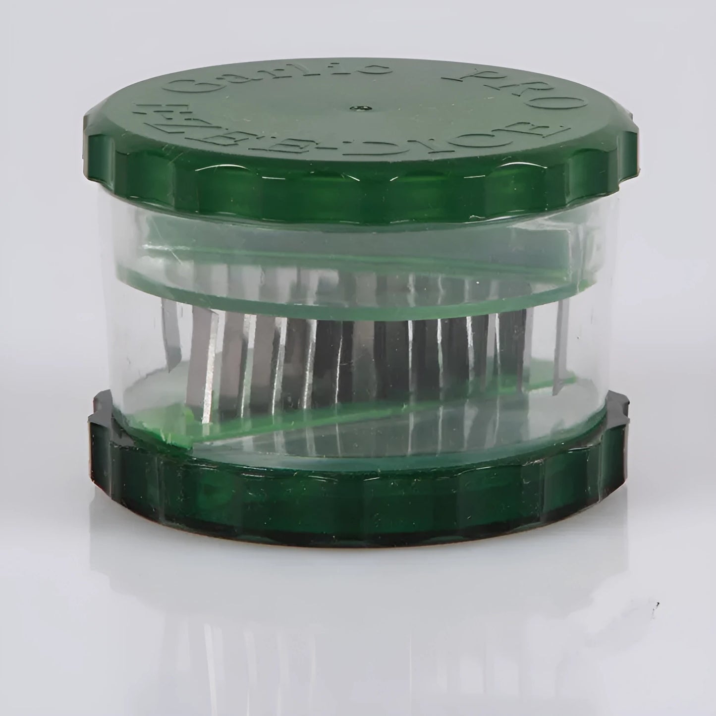Transparent green garlic peeler measuring 8.5 by 8.5 by 6 centimetres with garlic cloves visible inside
