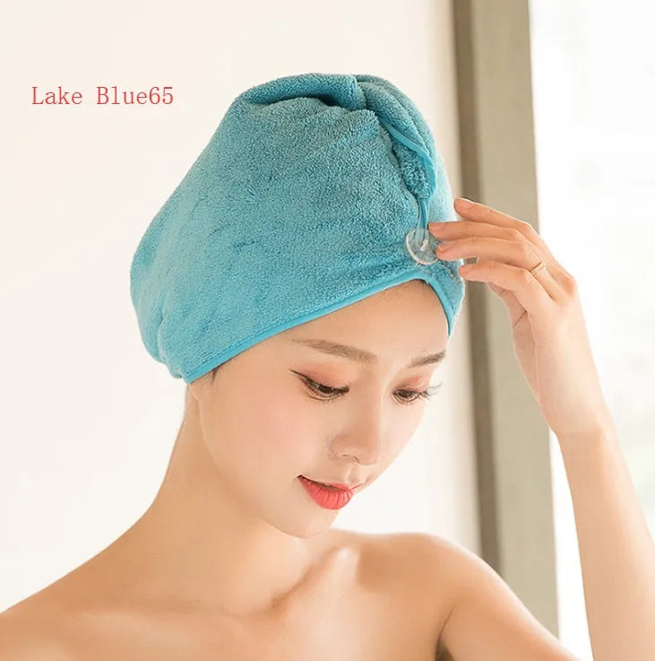 A woman wearing a sky blue microfiber hair dryer cap, with wet hair tucked inside, showing the towel's wrap-around design.
