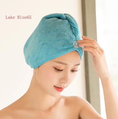 A woman wearing a sky blue microfiber hair dryer cap, with wet hair tucked inside, showing the towel's wrap-around design.