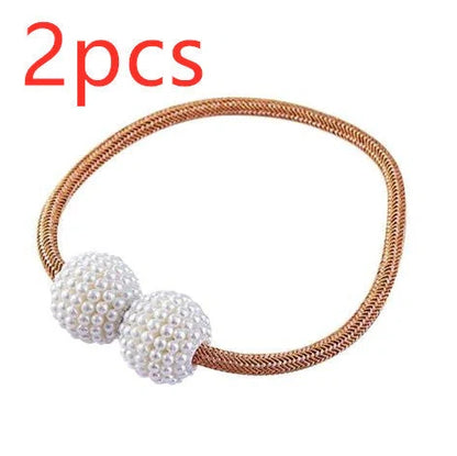 Magnetic curtain tiebacks with white pearl beads and fabric loops holding gathered curtain