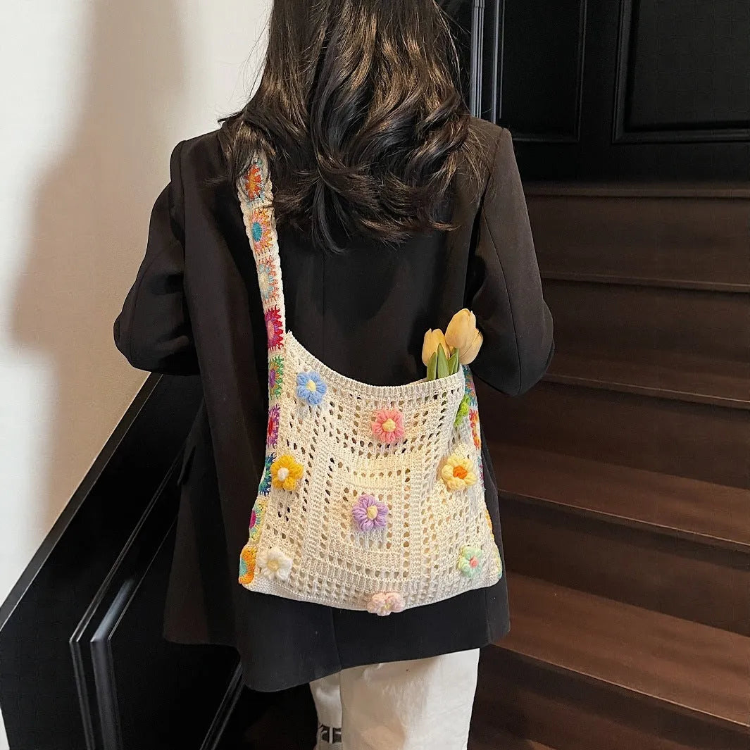 Women's large white knitted shoulder bag with hollow weave pattern and single strap.