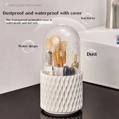 White rotating acrylic makeup brush holder with transparent dustproof lid on a desktop.