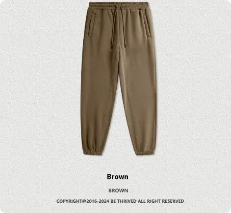 Man wearing solid colour cotton velvet sweatpants with an ankle banded design in a dark grey shade.