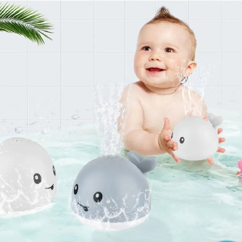 Grey or white electric whale bath toy spraying water with LED lights on a base.