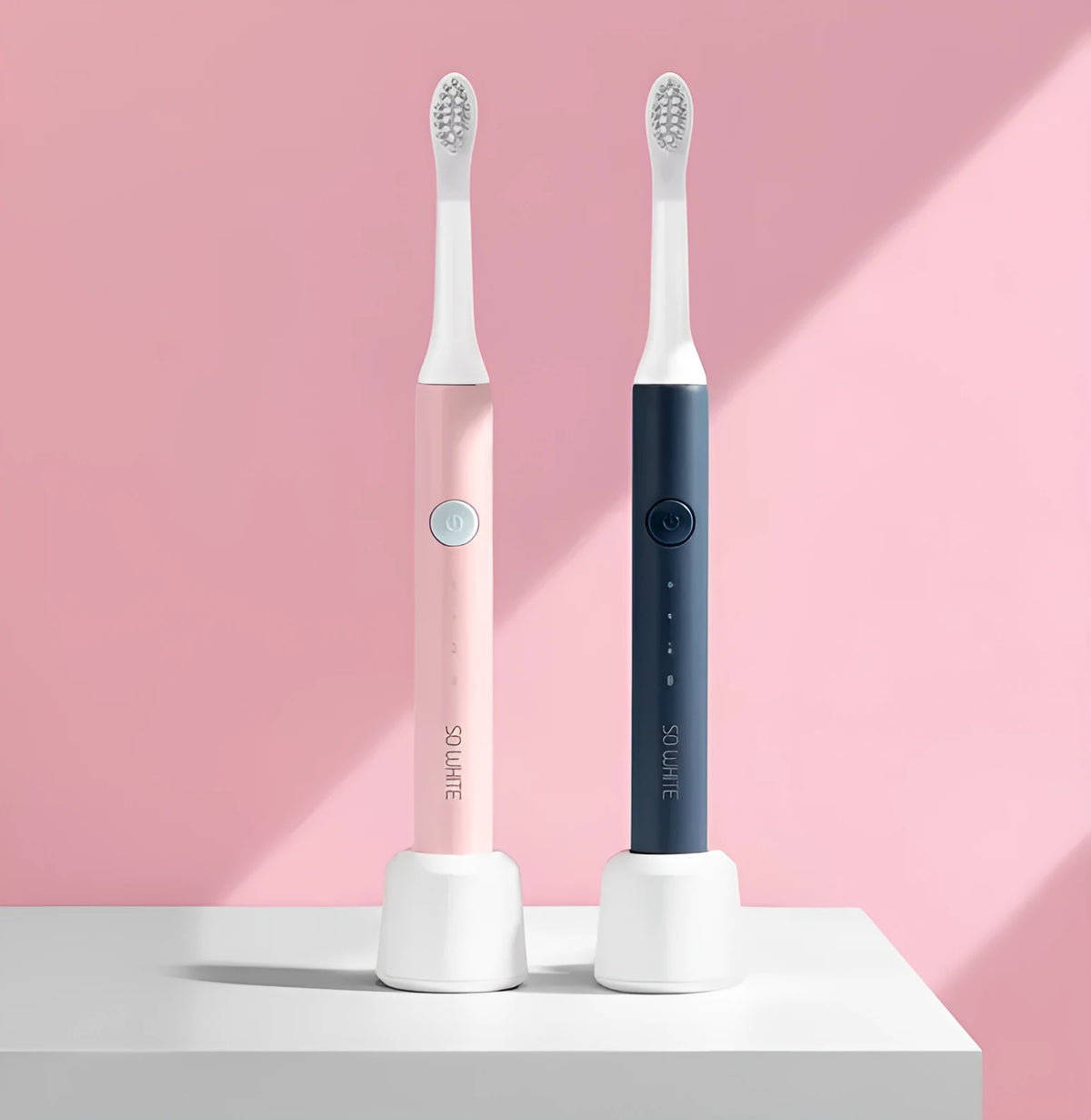SOOCAS sonic electric toothbrush in blue or pink with round brush head on a bathroom counter.