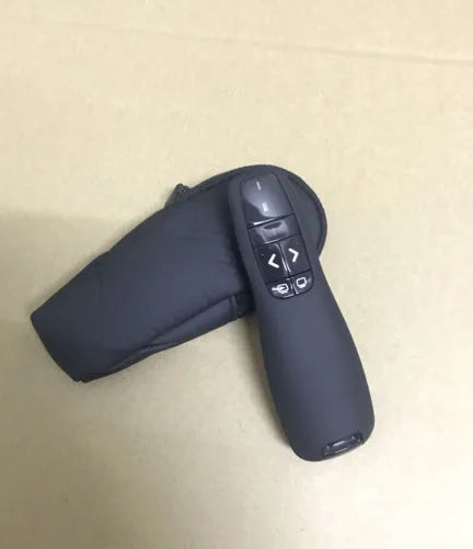 Black wireless presentation remote pen with laser pointer and stored USB receiver.