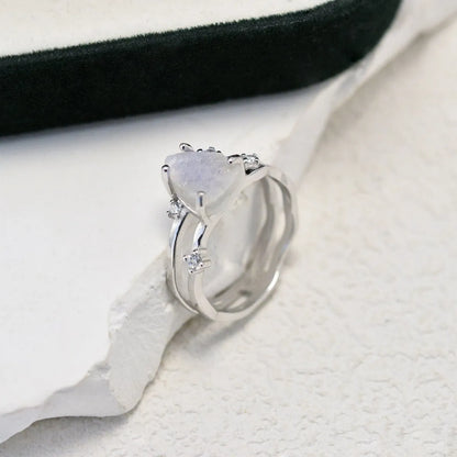 S925 sterling silver ring with an irregular triangular bezel holding a genuine cabochon moonstone, on a model's finger.