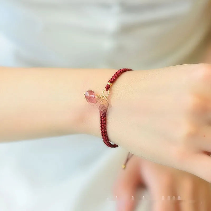 Women's adjustable bracelet with natural strawberry quartz cherry-shaped crystal charms on a chain.