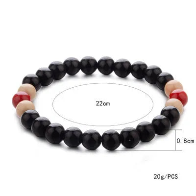 An ethnic-style natural stone bead bracelet with lava stones on a wrist.