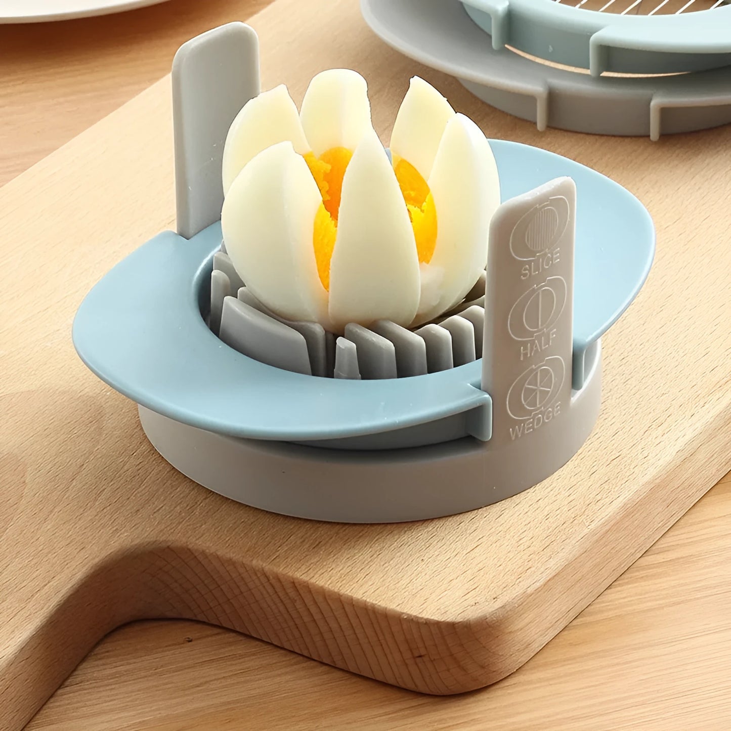 Three-function manual egg cutter in blue with stackable design for kitchen use