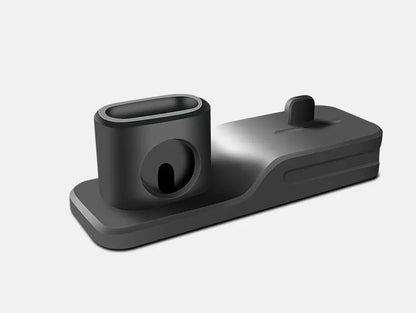 Black silicone 3-in-1 charging stand for Apple iPhone, Apple Watch, and AirPods on a desk