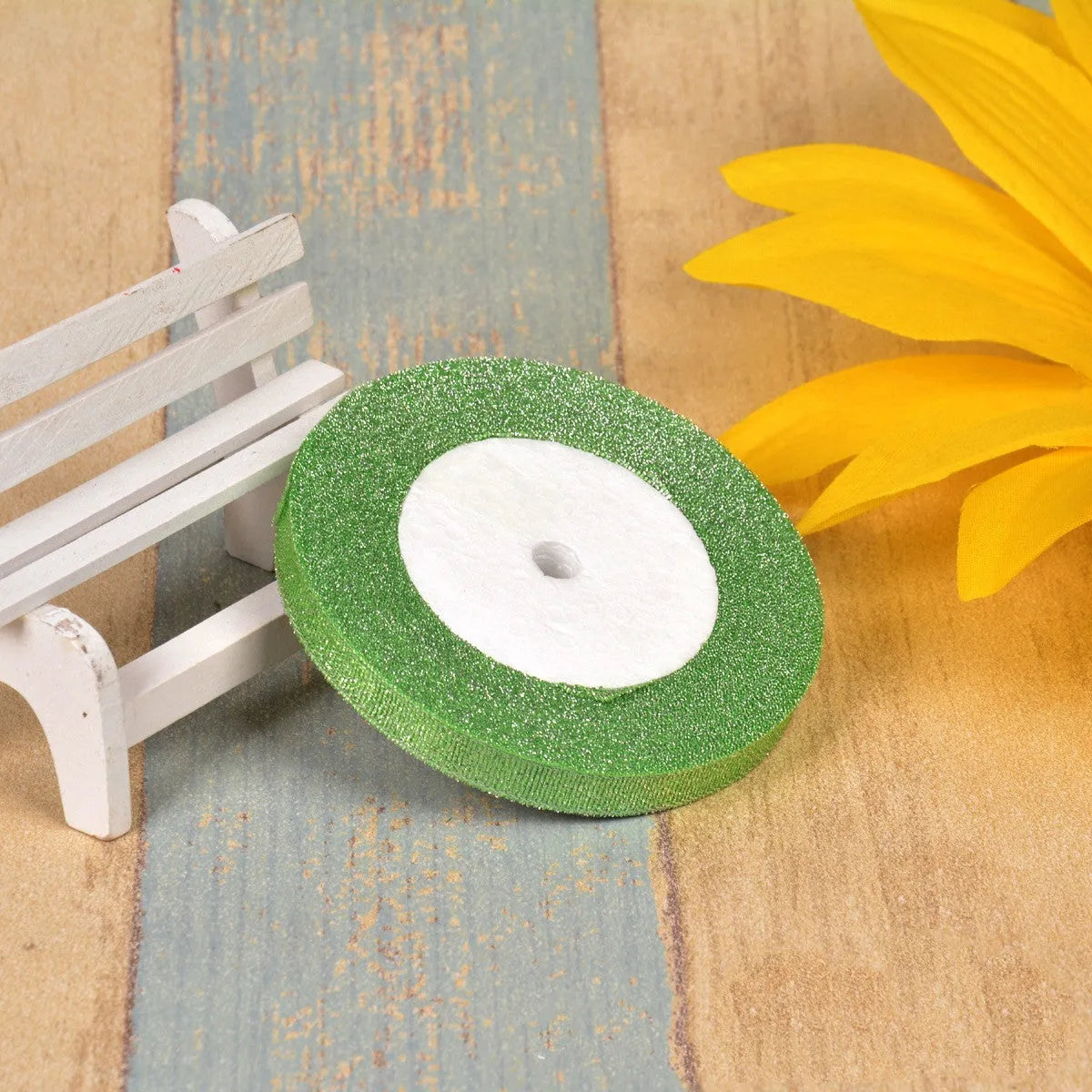 Close-up of green onion patterned ribbon with gold wire on a 25-yard roll, showing 3-points width.