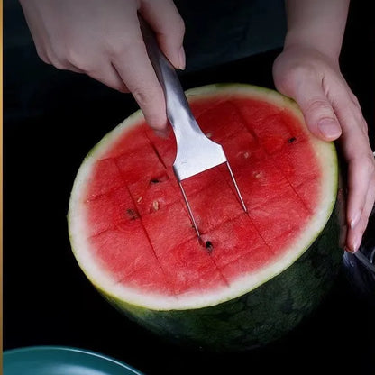 Stainless steel watermelon slicer and serving fork on a kitchen counter.