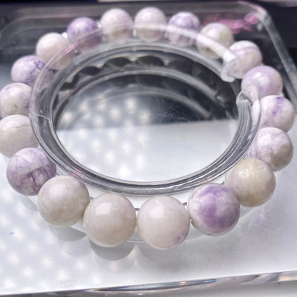 Close-up of a purple turquoise gemstone bead bracelet with an adjustable leather cord fastening.