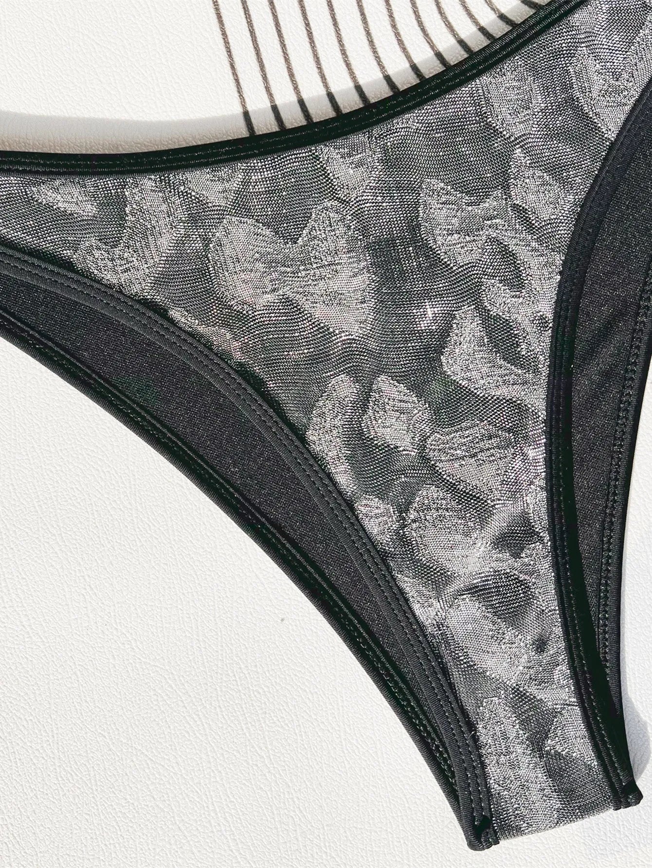 Black two-piece ladies bikini swimsuit with adjustable straps, shown on a model.